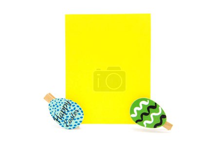Grußkarte mit Wäscheklammern und gefärbten Eiern isoliert auf weißem Hintergrund. Kopierraum. Freiraum für Text. Frohe Ostern!