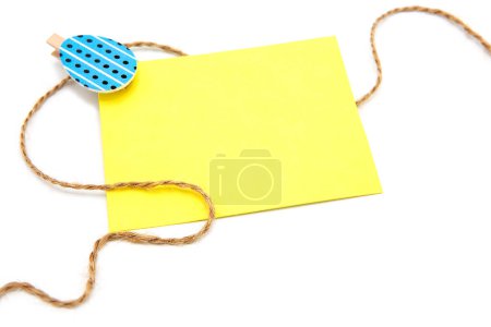 Greeting blank card with rope on clothespins with colored eggs isolated on a white background. Copy space. Free space for text. Happy easter!