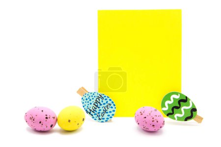 Tarjeta de felicitación en blanco con pinzas de ropa y huevos de colores aislados sobre un fondo blanco. Copiar espacio. Espacio libre para texto. Feliz Pascua.!