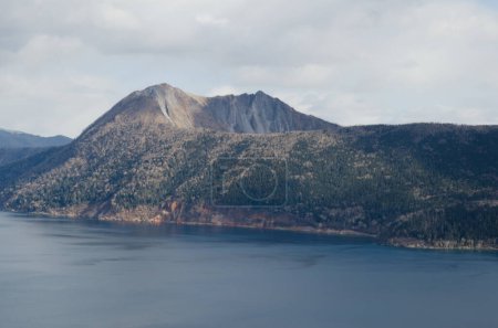 Foto de Monte Kamui elevándose por encima del lago Mashu. Parque Nacional Akan Mashu. Hokkaido. Japón. - Imagen libre de derechos