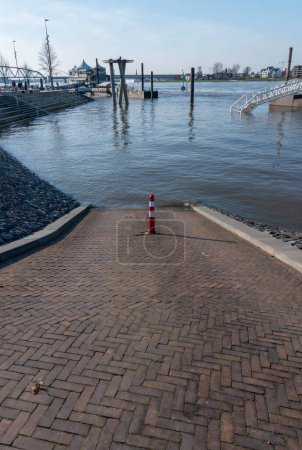 Photo for Nijmegen, The Netherlands 4 April 2023: The river the waal is flooding because of global warming, the road is going into the water - Royalty Free Image