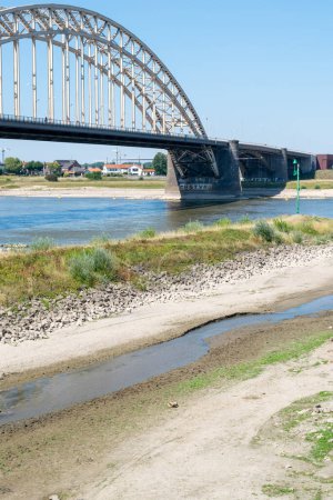 Foto de Nijmegen, Países Bajos, 11 de agosto de 2022: El canal 'Het Meertje' del río Waal se ha estrechado debido a la sequía y la escasez de agua debido al calentamiento global - Imagen libre de derechos