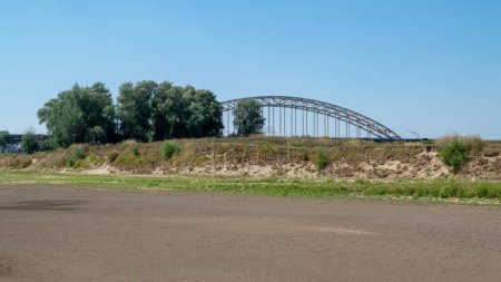 Photo for Nijmegen, The Netherlands, August 11, 2022:  The gully of the Waal in front of the Waalbridge called 'Het meertje' has dried out due to global warming, the soil in Europe has become extreme dry in the summer - Royalty Free Image
