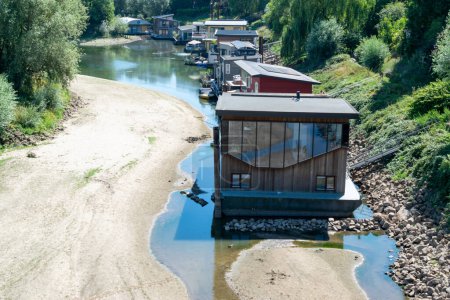 Foto de Nijmegen, Países Bajos, 11 de agosto de 2022: Casa flotante de pie en el suelo debido a la tierra seca - Imagen libre de derechos