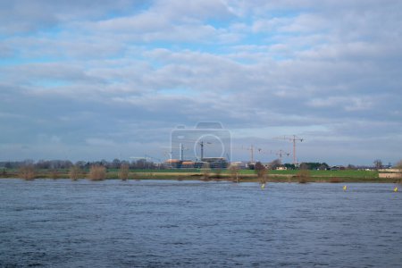 Téléchargez les photos : Nijmegen, Gueldre, Pays-Bas, 21 janvier 2023, Travaux de construction de bâtiments de grande hauteur avec grues en face de la rivière Waal - en image libre de droit