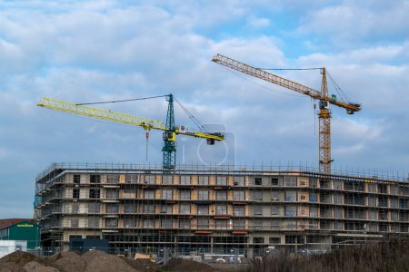 Photo for Nijmegen, the Netherlands - DJanuary 21, 2023: Construction work being done on high rise buildings with several crane, building a shopping centre in Nijmegen Lent - Royalty Free Image