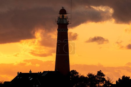 the red lighthouse in Schiermonnikoog  in front of the sunset
