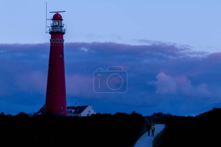 Téléchargez les photos : Le phare rouge de Schiermonnikoog à l'heure bleue, le soir, dans la province de Frise, aux Pays-Bas - en image libre de droit