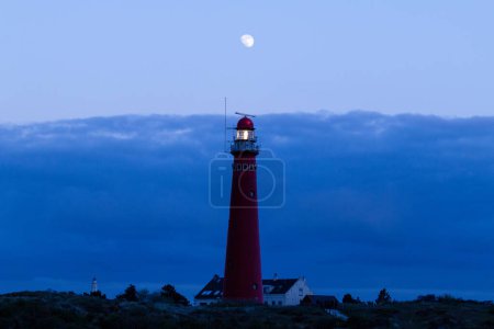 Téléchargez les photos : Le phare rouge de Schiermonnikoog à l'heure bleue, le soir, dans la province de Frise, aux Pays-Bas - en image libre de droit