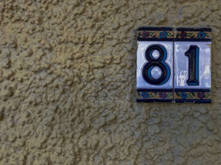 Photo for Ceramic plaques placed on the wall with the number eighty-one - Royalty Free Image