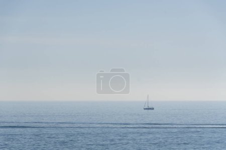 Segelschiff mit abgesenkten Segeln, Horizont im Hintergrund und ruhiger See.