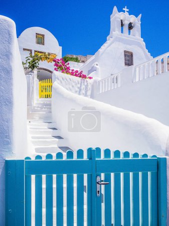 Foto de Una hermosa casa con una puerta azul en la isla de Santorini, con una escalera blanca con cielo azul - Imagen libre de derechos