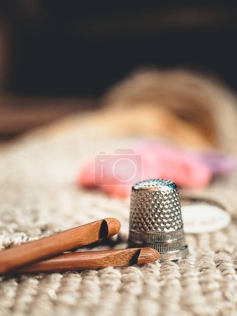 Photo for Spools of thread and basic sewing tools including pins, needle, a thimble, and tape measure on a wooden tabletop. High quality photo - Royalty Free Image
