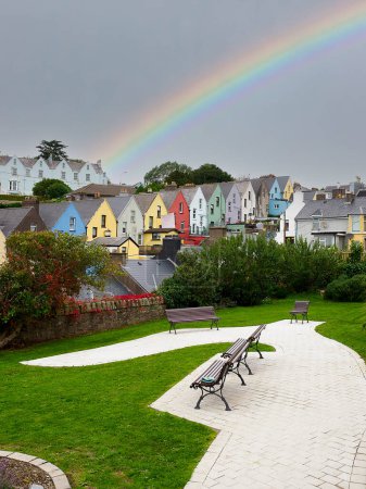 Téléchargez les photos : Un arc-en-ciel par temps nuageux, avec un parc au premier plan dans la ville de Cobh, en Irlande. Photo de haute qualité - en image libre de droit