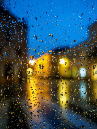 Foto de Encantadoras gotas de lluvia nocturnas: capturando la belleza etérea de Bokeh en una serena sinfonía nocturna de luz y agua. Foto de alta calidad - Imagen libre de derechos