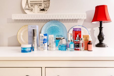 Photo for Surrey, B.C., Canada - 04.16.24 - Group of hyaluronic acid product brands for skin hydration displayed with their retail packaging in a bedroom setting, depicting a skin care routine concept. - Royalty Free Image