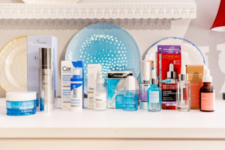 Photo for Surrey, B.C., Canada  - 04.16.24 - Group of hyaluronic acid product brands for skin hydration displayed with their retail packaging in a bedroom setting, depicting a skin care routine concept. - Royalty Free Image