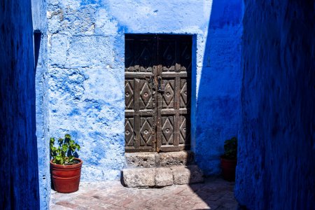 puertas antiguas en paredes rojas y azules dentro de un monasterio en la ciudad Inca de Cusco en Perú