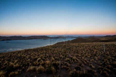 panorama of Lake Umayo and grasslands at the village of Puno on Lake Titicaca with views of the Andes and sun-baked bushes of the Andes in the Peruvian highlands