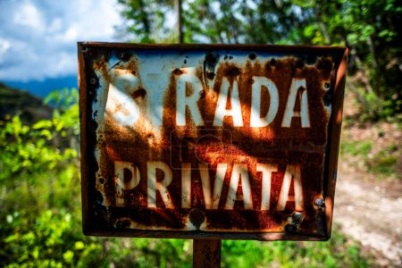 Téléchargez les photos : Panneau métallique rouillé par le temps avec les mots route privée dans les bois - en image libre de droit