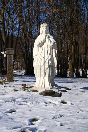 Photo for Lublin, Poland. 08 February 2023. White figure of Virgin Mary in snow outside old church in winter. - Royalty Free Image