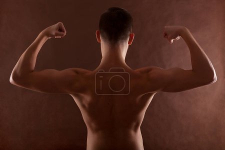 Photo for Handsome muscular shirtless adolescent boy flexing muscles. - Royalty Free Image