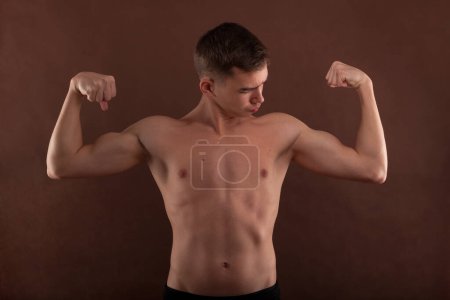 Photo for Handsome muscular shirtless adolescent boy flexing muscles. - Royalty Free Image