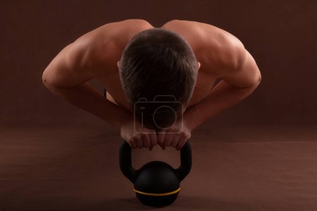Photo for Handsome muscular shirtless adolescent boy in plank exercise. - Royalty Free Image