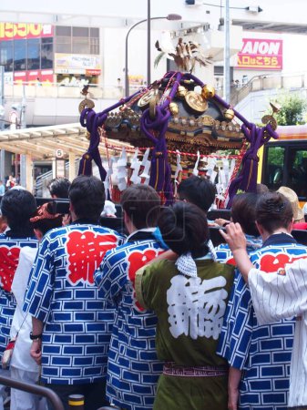 Foto de Japonés "Natsumatsuri" (festival de verano) con la gente vistiendo los vestidos tradicionales que llevan un objeto religioso. - Imagen libre de derechos