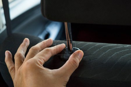 Photo for Hand adjusts headrest in car interior. adjusting the seat position in the car - Royalty Free Image