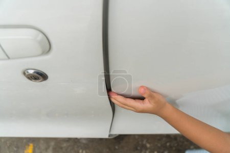 Photo for Kid hand or finger pinched by the car door; close up portrait of finger pinched, slammed by the car door, accident concept; 4 year asian little girl hand or finger model. - Royalty Free Image