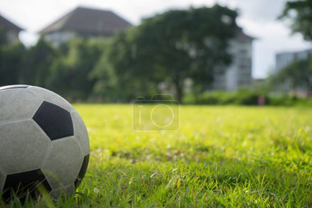 Photo for A ball for street soccer football under the sunset ray light in grass  field area with abstract lights blurred bokeh copy space. - Royalty Free Image