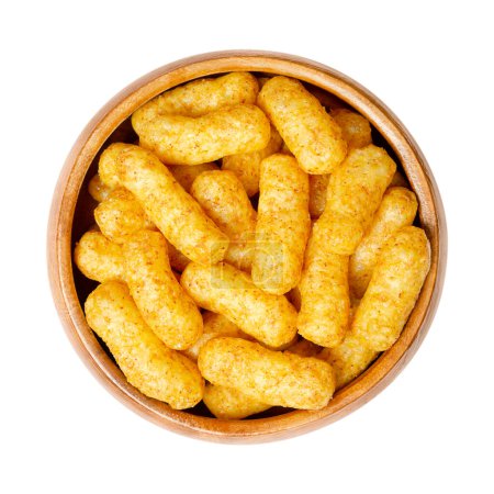 Peanut flips, in a wooden bowl. Also known as Bamba, peanut puffs or snips, is a puffed, peanut-flavored corn snack, with a peanut content up to a third. Close-up, from above, isolated, macro photo.