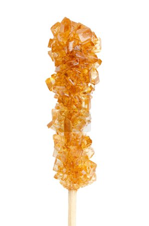 Photo for Brown rock candy, sugar candy on a wooden stick, close-up, from above, isolated, on white background. Also called rock sugar or crystal sugar, a type of confection composed of large sugar crystals. - Royalty Free Image