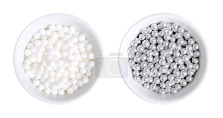 Photo for White and silver colored sugar pearls for decorating, in white bowls. Edible dragees and decorative balls, also known as love pearls, with a diameter of 4 mm, used as a topping for sweet treats. - Royalty Free Image