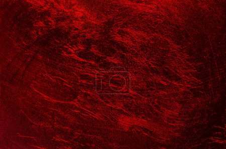 Schimmernde metallische Kunststofffolie und dunkelroter Hintergrund mit zufällig strukturierter Oberfläche. Zerfurcht und mit einer Textur, die aussieht wie Hölle, Lava oder die Oberfläche des Planeten Mars. Nahaufnahme, von oben.