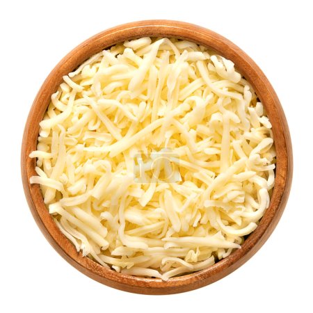 Foto de Queso mozzarella rallado, en un tazón de madera. Mozzarella rallada de baja humedad, un queso italiano, hecho de leche de vaca pasteurizada, enrollada en almidón para evitar que se pegue. Utilizado para pizza y pasta. - Imagen libre de derechos
