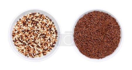 Chocolate nonpareils and sprinkles, in white bowls. Tiny chocolate balls and rod-shaped choco sprinkles, used as sweet decoration and topping for cookies, cakes and ice cream. Isolated, from above.