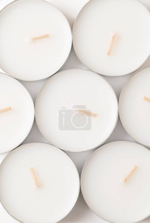 Photo for Group of large tealights, long-burning candles, from above. Also known as nightlights, tea lites, t-lites or t-candles in thin metal cups, so that the wax can liquefy completely while lit. - Royalty Free Image