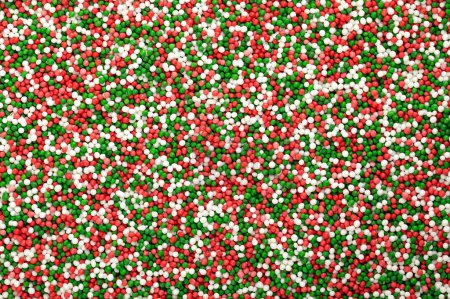 Photo for Colorful sprinkles made of tiny sugar balls. Green, red and white mix of nonpareils. Decorative and edible Hundreds and Thousands made of sugar and starch, used as sweet decoration and as topping. - Royalty Free Image