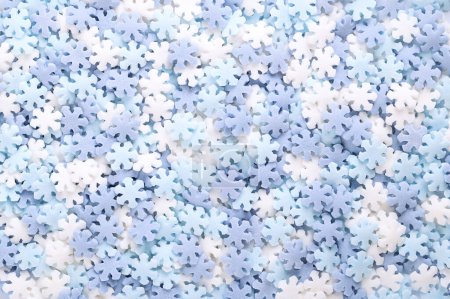 Photo for Snowflake shaped sugar sprinkles. Background of blue and white confetti candy, confectionery made of sugar and rice, consisting of flat multi colored candy sprinkles, used as sweet edible decoration. - Royalty Free Image