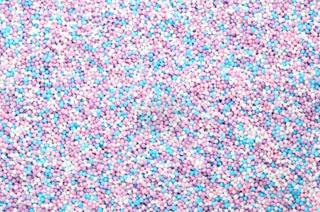 Foto de Espolvoreos coloridos hechos de pequeñas bolas de azúcar. Mezcla de púrpura, azul, rosa y blanco nonpareils. Decoración y comestible Cientos y miles de azúcar y almidón, utilizados como decoración y como relleno. - Imagen libre de derechos