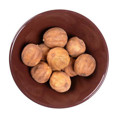 Photo for Whole dried limes, in a brown ceramic bowl. Also loomi, black lime, noomi basra, and limoo amani. Strongly flavored, sun-dried fruits, used in the Middle Eastern as sour spice or for dried lime tea. - Royalty Free Image