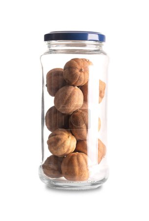 Photo for Whole dried limes, in a glass jar with lid. Loomi, black lime, noomi basra, or also limoo amani, strongly flavored, sun-dried fruits, used in the Middle Eastern as sour spice or for dried lime tea. - Royalty Free Image