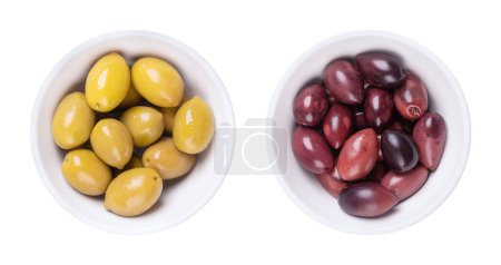 Photo for Green and Kalamata olives with pit, pickled whole, large Greek table olives, in white bowls. Green olives picked when still unripe, and Kalamata olives picked when ripe, both preserved in a brine. - Royalty Free Image