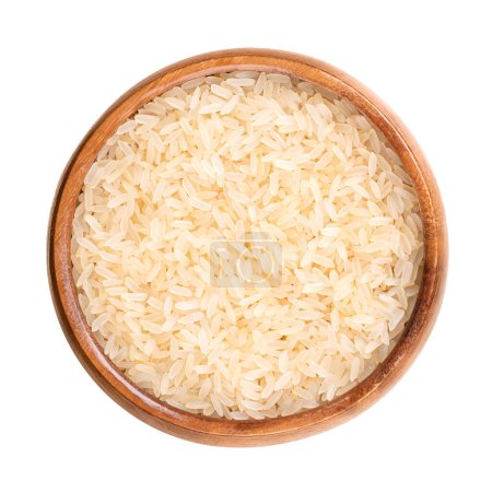 Photo for Parboiled long grain rice, in a wooden bowl. Also called converted, easy-cook or sella rice, or miniket. Partially boiled in the husk. Parboiled in three basic steps of soaking, steaming and drying. - Royalty Free Image