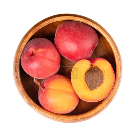 Albaricoques frescos en un tazón de madera. Frutos pétreos de Prunus armeniaca, similares a un pequeño melocotón. Frutas amarillas, teñidas de rojo en el lado más expuesto al sol, con una superficie lisa, y de sabor dulce a ácido.