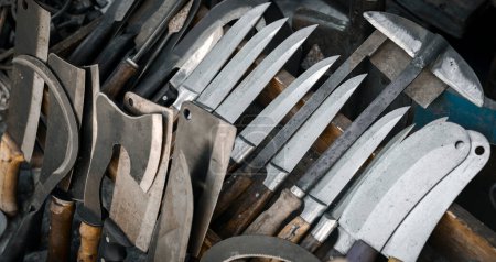 Téléchargez les photos : Différents types de couteaux, haches, cliveurs et autres types d'outils tranchants sur l'affichage d'une ancienne quincaillerie. - en image libre de droit