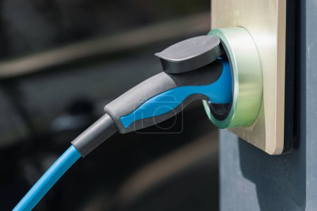 Closeup photo of the socket of an electric car charger in station on street. Renewable energy in transportation concept.