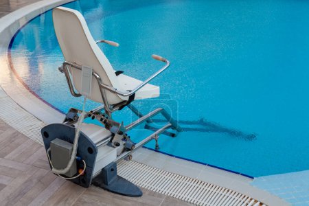 Pool lift device for disabled people in outdoor swimming pool. Physical therapy concept.